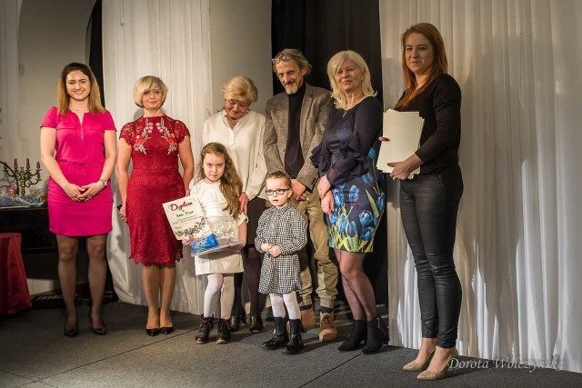 Laureatka I miejsca, Nadia Cieślik z Przedszkola Publicznego numer 7, pokazuje dyplom. Za nią członkowie jury i nauczyciele.