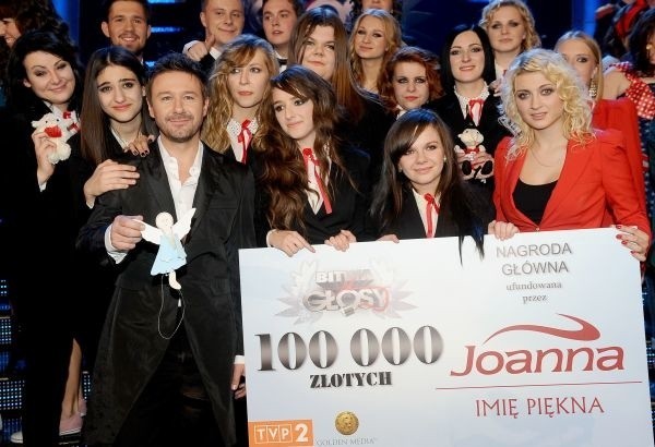 Andrzej Piaseczny ze swoją drużyną i symbolicznym czekiem na 100 tysięcy złotych.
