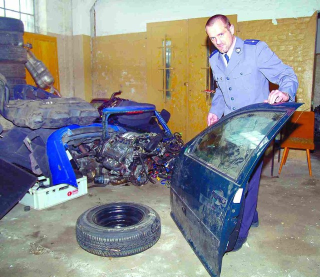 Mariusz Łyszyk, rzecznik koszalińskiej policji, pokazuje to, co zostało z eleganckich niemieckich samochodów.