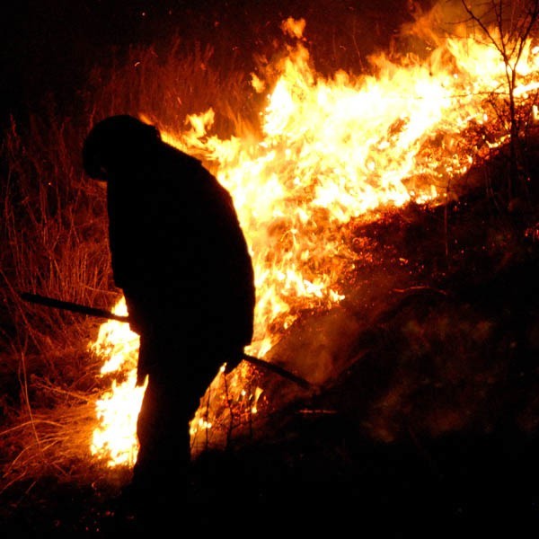 Strażak gasi ogień, który dzisiejszego popołudnia strawił suchą roślinność na zboczach Kopca Tatarskiego w Przemyślu.