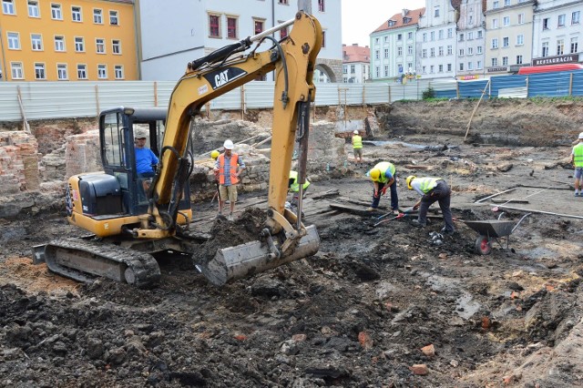 Ekipa budowlano-archeologiczna podczas prac na nyskim rynku. Na powierzchni widać pozostałości XIII-wiecznej zabudowy, które być może są fragmentami dawnych ulic bądź izb.