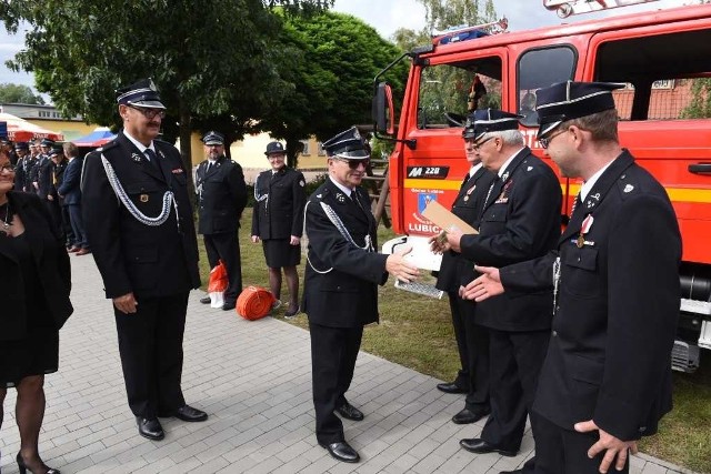 Wójt Marek Olszewski ( w środku) gratuluje strażakom nowego wozu