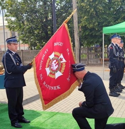 Prezes jednostki strażackiej w Lipie druh Damian Plęsa pocałował sztandar i dokonał jego prezentacji