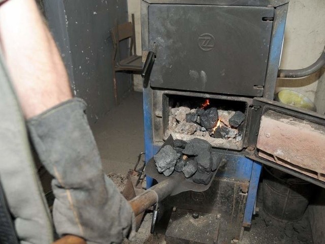 Kocioł na paliwo stałe - dokładanie opałuDo toruńskich pieców trafia nie tylko węgiel, ale i śmieci.