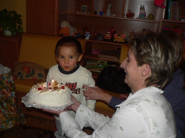 Podczas urodzin chłopiec z wielką powagą zdmuchiwał świeczki na urodzinowym torcie.