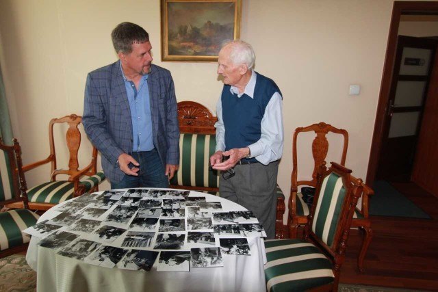 Janusz Buczkowski prezentuje autorskie zdjęcia dawnego jarmarku chłopskiego Jarosławowi Karysiowi, zastępcy dyrektora Muzeum Wsi Kieleckiej.