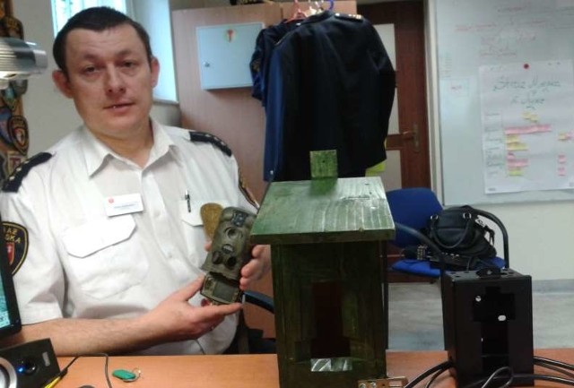 Strażnik Adam Sadłowski prezentuje fotopułapkę wraz z cała otoczką, czyli budka lęgową. Strażnicy mówią, że gdyby nie one, niektórych śmieciarzy nigdy w życiu nie można byłoby przyłapać.