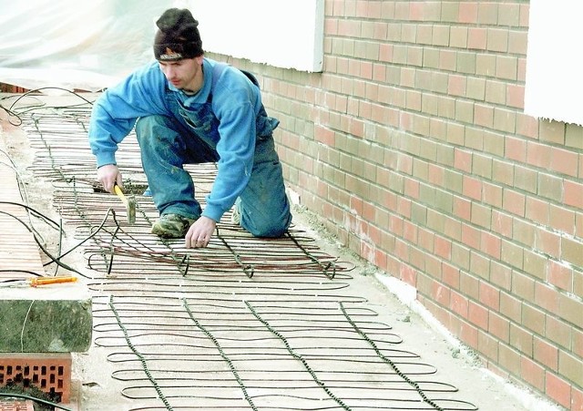 Układanie kabli grzewczych pod domem. Całość zalewa się betonem lub cementem