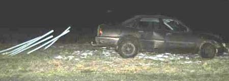 Za uszkodzonym samochodem widać sześć metalowych słupków na których stały znaki drogowe 