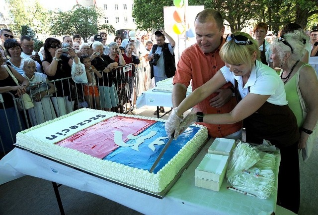 Prezydent Piotr Krzystek kroi tort urodzinowy.