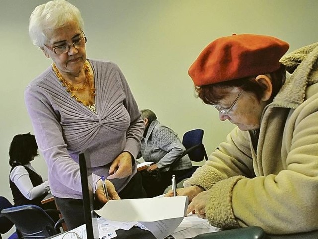 Panie Wanda Żywień (w środku) oraz Małgorzata Wiśniewska (w tle z lewej) pomagały wczoraj poszkodowanym wypełnić oświadczenia o odstąpieniu od umowy