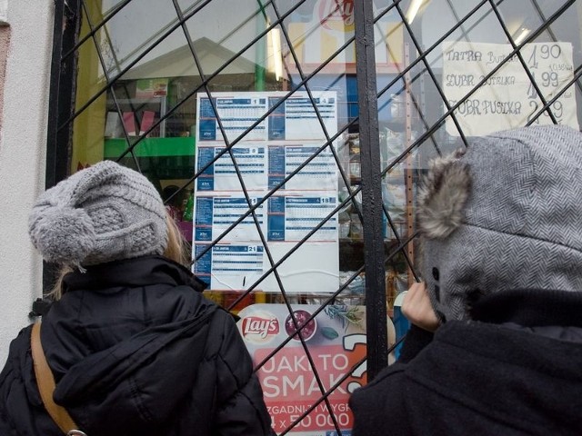 Pasażerowie o godzinach odjazdów autobusów z przystanku przy ul. Armii Krajowej dowiadują się z rozkładów powieszonych na szybie pobliskiego sklepu.