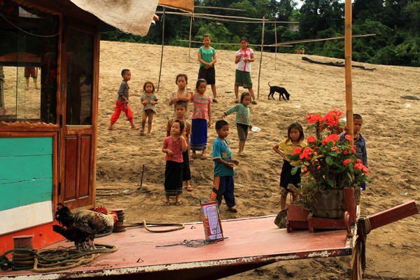 Dzieci na brzegu Mekongu czekają na turystów.