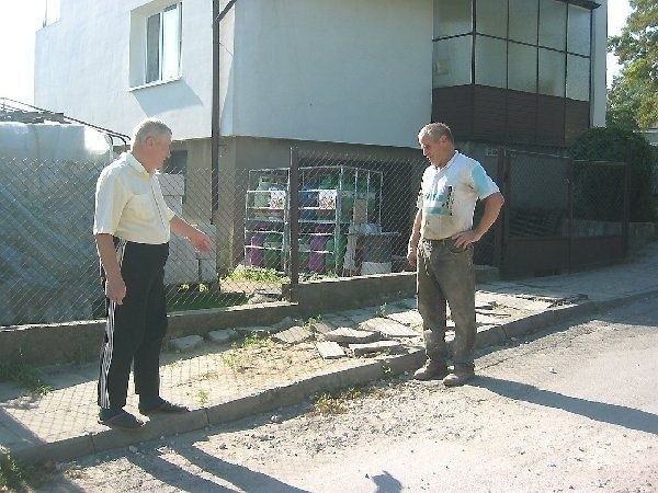 Stanisław Lorenc i Kazimierz Wodzyński,  mieszkańcy oczekujący na remont swoich ulic,  pokazują zrujnowane fragmenty nawierzchni i  chodników