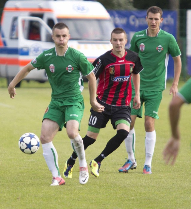 Fragment meczu, Radomiak 1910 SA Radom - Stal Stalowa Wola, który rozegrano 15 czerwca 2013 roku na stadionie Radomiaka. Zakończył się wynikiem bezbramkowym. Z piłką Jakub Cieciura, obrońca Radomiaka, w środku gracz Stali, Damian Łanucha, z tyłu pomocnik "zielonych" Mateusz Radecki.