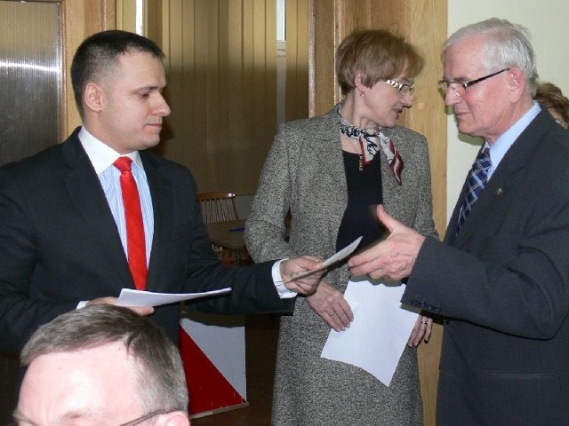 Przewodniczący rady powiatu Eugeniusz Cichoń odbiera kartę do głosowania. 