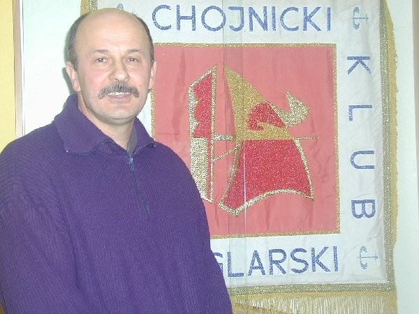 Krzysztof Pestka na tle sztandaru Chojnickiego  Klubu Żeglarskiego.