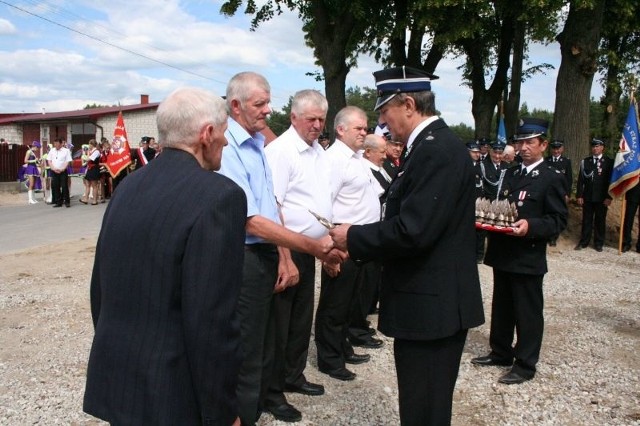 Wójt wręcza statuetki zasłużonym strażakom