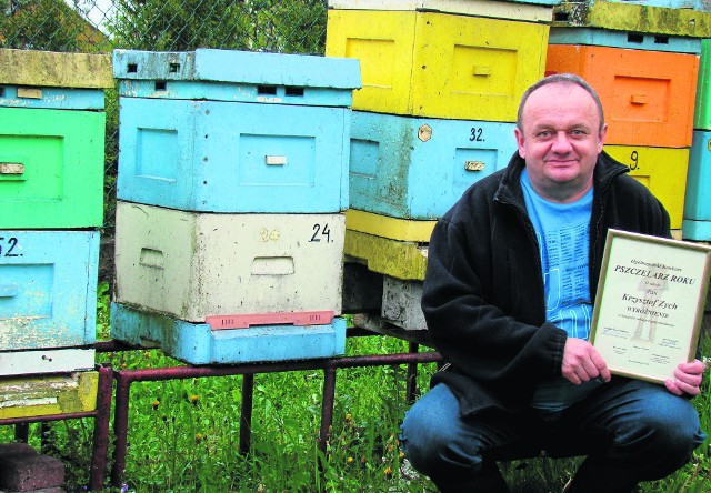 Krzysztof Zych w swojej pasiece prezentuje cenne wyróżnienie