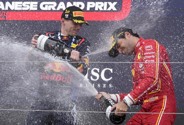 Carlos Sainz Jr oblewa się szampanem z Maxem Verstappen po wyścigu F1 Grand Prix Japonii na torze Suzuka