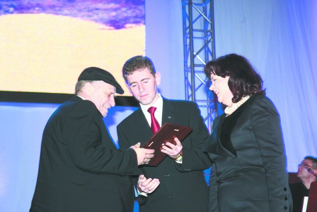 Malarzowi Leonowi Tarasewiczowi (z lewej) tytuł wręczali wojewoda podlaski Maciej Żywno i minister nauki Barbara Kudrycka