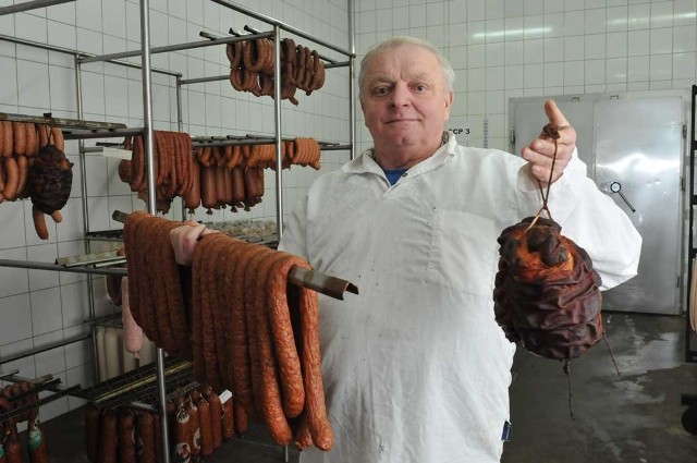 Kazimierz Stoltman, kierownik masarni w Smardzku, w jednej ręce trzyma laski kiełbasy kruchej domowej, a  w drugiej szynkę świdwińską. Ta ostatnia trafia na lokalne stoły tylko przed świętami