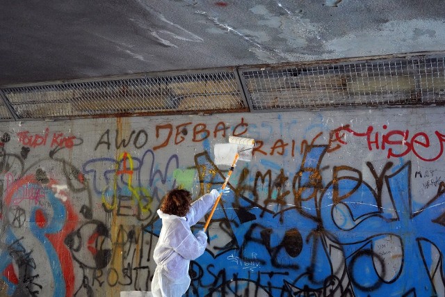 Zamalowywanie nienawistnych napisów w przejściu podziemnym w Olkuszu