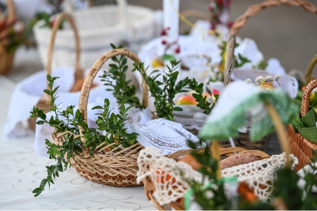 Wśród tradycyjnych dekoracji koszyka wielkanocnego znajdują się gałązki barwinka i wykrochmalone serwetki. Kliknij, aby zobaczyć produkty wchodzące w skład święconki.