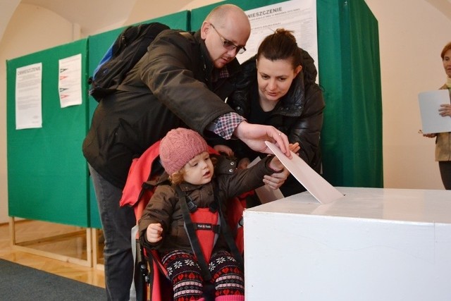 Wybory parlamentarne 2015 w Bielsku-Białej. 2-letnia Jadwiga Kasprzak pomaga rodzicom wrzucić karty do głosowania do urny wyborczej