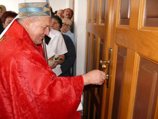 Biskup Edward Frankowski otwiera drzwi do świątyni kluczami przekazanymi mu przez społeczny komitet budowy kościoła.