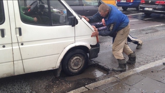 Kierowca forda wyjechał dopiero, gdy kilka osób pomogło wypchnąć z dziury jego auto.