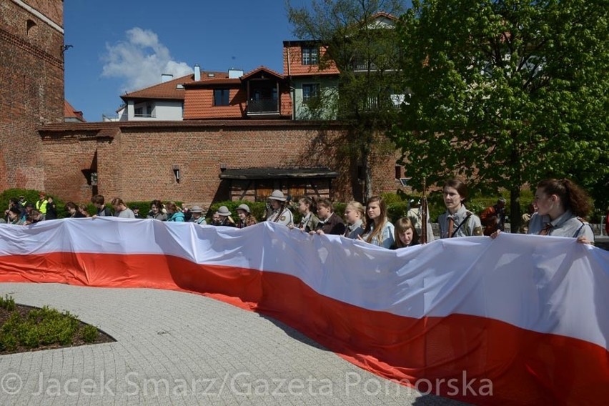 Harcerze z flagą na skwerze