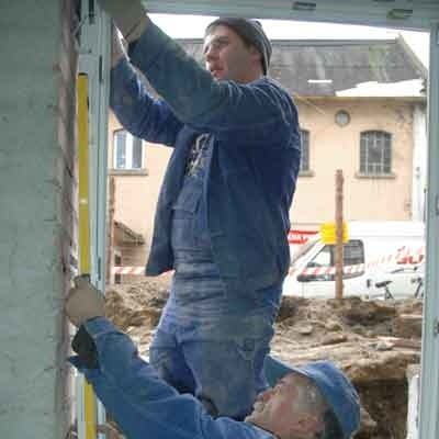 Fachowcy z firmy Rembud Andrzej Szkuta i Roman Bilon kończą wymianę okien w piwnicy