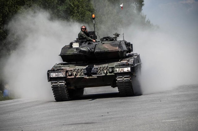 Żar lał się z nieba a w zębach czuć było poligonowy pył, ale to nie przeszkodziło polskim czołgistom z 34 Brygady Kawalerii Pancernej z Żagania zakończyć pierwszy dzień zawodów Strong Europe Tank Challenge z doskonałymi wynikami. 4 czerwca Polacy przystąpili do pierwszych czterech konkurencji.Chwilę po 8 rano stado „Żagańskich Lwów” czyli cztery Leopardy 2A5 wyruszyły z parku w kierunku pierwszego punktu zawodów – wykrywania sił, sprzętu i rodzajów uzbrojenia przeciwnika w terenie zabudowanym. Brabantczycy w wielkim skupieniu rozpoczęli obserwację terenu gdzie, według informacji miał się ukrywać przeciwnik. Po niespełna kilkunastu minutach prawie wszystkie cele zostały bezbłędnie wykryte a o ich wykryciu zameldowano. Kierownik konkurencji, por. Steve Nelson z amerykańskiej armii bardzo chwalił polskich czołgistów.- Polscy żołnierze byli absolutnie doskonali. W bardzo krótkim czasie wykryli siły i środki przeciwnika, świetnie meldowali i zrobili to naprawdę bardzo szybko. Jestem przekonany, że mają szansę na pierwsze miejsce. Gramy fair dla każdej drużyny a Polacy wykonali dzisiaj kawał dobrej roboty. Mogę podkreślić, że działali bardzo sprawnie jako drużyna, szczególnie kiedy mówimy o stanowiskach obserwacyjnych, byli po prostu świetni i wychwycili wszystko co było do zaobserwowania – ocenił polskich czołgistów kierownik konkurencji, por. Nelson.Kolejnym zadaniem jakie czekało na Polaków było obliczenie odległości do dziesięciu ukazujących się celów bez użycia celownika laserowego. Żołnierze bazowali jedynie na optyce i na jej podstawie wyliczali odległości. Również w tej konkurencji uplasowali się w czołówce drużyn z dzisiejszego dnia zawodów.Trzecie zadanie, do którego przystąpili dziś czołgiści wymagało od nich bardzo dobrej kondycji fizycznej. Polacy strzelali z broni osobistej na czas. Liczyła się oczywiście celność i jak największa liczba trafień jednak strzelanie składało się z czterech punktów. Każdy żołnierz musiał oddać strzały do ukazujących się celów w pozycji leżącej, klęczącej oraz stojącej. Jednak dla utrudnienia w trakcie wykonywania tej konkurencji czołgiści musieli przebiec ok 300 m z dwiema skrzynkami amunicji, wejść i wyjść z czołgu a wcześniej jeszcze pięcioma strzałami trafić w sam środek tarczy.  Pytany o kondycję i umiejętności strzeleckie Polaków, kierownik konkurencji, sierż. sztab. Glen Fretheim nie krył podziwu.- Polscy żołnierze natychmiast zrozumieli czego od nich oczekujemy podczas wykonywania tej konkurencji byli bardzo skupieni i dokładni. Na pewno jeśli chodzi o strzelanie z czołgu, nie było celu którego by chybili. Wiedzieli dokładnie co mają robić, biegli szybko, biegli mocno i wykonali tę konkurencję doskonale. Są bardzo wysportowani, gotowi do działania i byłbym bardzo szczęśliwy i zaszczycony gdybym w trakcie walki miał ich obok siebie – chwalił żagańskich czołgistów sierż. Fretheim.Ostatnią konkurencją z jaką przyszło się zmierzyć pancerniakom z Hetmańskiej brygady w pierwszym dniu zawodów w niemieckim Grafenwoerth było rozpoznawanie sprzętu. Poruszając się czołgami po wyznaczonej drodze, załogi miały za zadanie odnaleźć trzydzieści tabliczek ze zdjęciami czołgów i śmigłowców rozmieszczonych w różnych odległości od trasy, którą poruszał się pluton. Również i z tym zadaniem czołgiści poradzili sobie perfekcyjnie. Z przygotowanych przez kierownika zadania trzydziestu sylwetek, żołnierze rozpoznali prawie wszystkie bo aż dwadzieścia osiem.Podsumowując dzień, jeden z dowódców czołgów, plut. Mariusz Klimkowski nie krył zadowolenia.- Oceniam dzisiejszy dzień bardzo dobrze, każdy z nas dał z siebie wszystko, szczególnie podczas strzelania i biegu ze skrzynkami z amunicją co muszę podkreślić było fizycznie niezwykle wyczerpujące. Dzisiejsze cztery konkurencje wypadły nam bardzo dobrze szczególnie w porównaniu do innych państw. Podejrzewam, że będziemy mieli wysoki wynik, bo każdy robił to co umiał najlepiej, nikt się nie oszczędzał. - podkreślał plut. Klimkowski.Pomimo skwaru, wszechobecnego pyłu i wyczerpujących konkurencji żołnierze z 34 Brygady Kawalerii Pancernej biorący udział w Strong Europe Tank Challenge podsumowali pierwszy dzień zawodów w niemieckim Grafen bardzo pozytywnie. Wtorek to dla pancerniaków z żagańskiej brygady pierwszy sprawdzian umiejętności ogniowych, podczas strzelania plutonu czołgów w natarciu.Źródło: ppor. Magdalena Czekatowskaoprac. (korn).Zobacz także: Wypadek z udziałem amerykańskich pojazdów wojskowych w Żaganiu. Spokojnie, to tylko ćwiczeniaŹródło:TVN24POLECAMY RÓWNIEŻ PAŃSTWA UWADZE:ronhorse zastąpiły Brygadę Sztyletów. Zmiana wojsk USA w Żaganiu