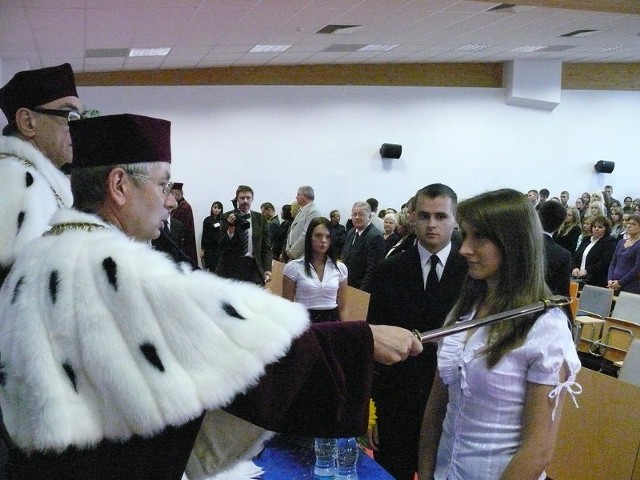 Doktor Tadeusz Dziekan, rektor WSEiP, mianuje jedną z nowych studentek I roku.