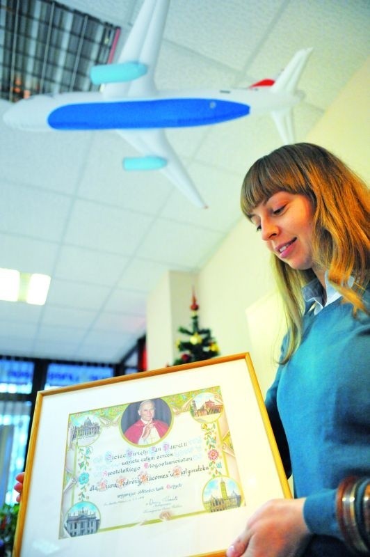 Marta Sarnocińska pokazuje certyfikat z błogosławieństwem Jana Pawła II dla podróżnych  Biacomexu
