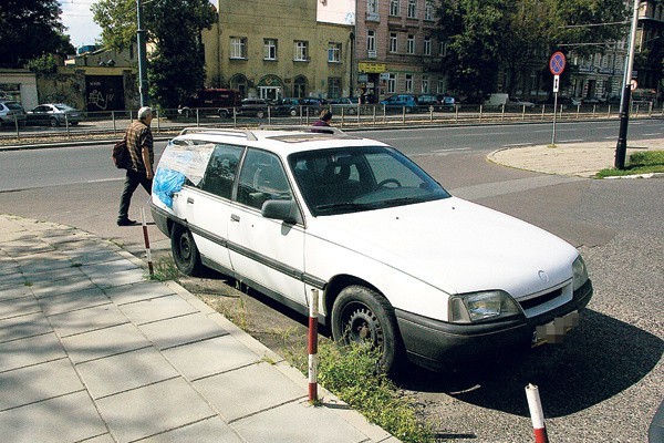 Zdezelowany opel stoi na drodze wjazdowej pomiędzy blokiem a hotelem Światowit.