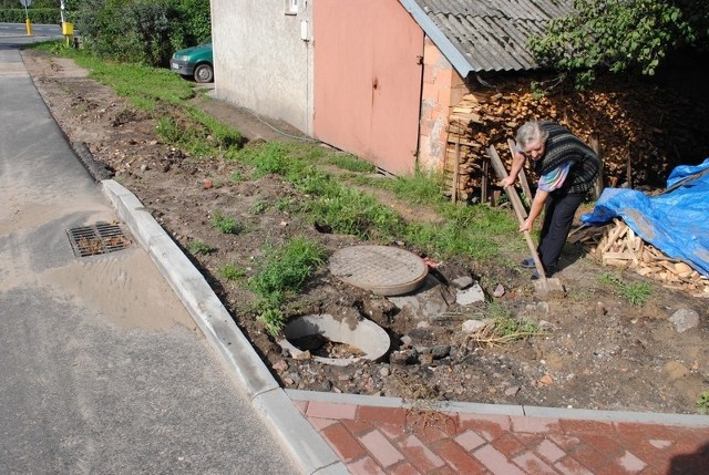 Pani Helena broniąc się przed zalewającą dom wodą żłobi rynnę w stronę pola pana Krzysztofa