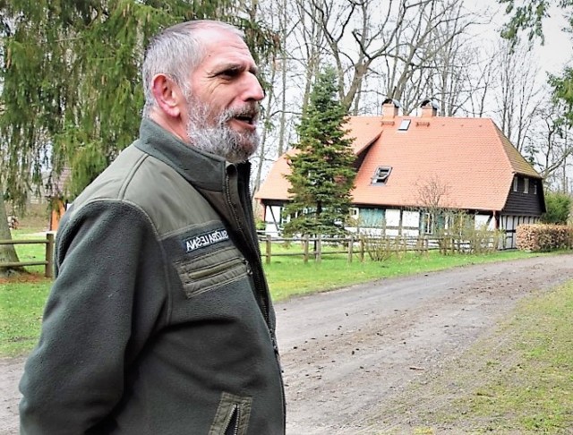 Tadeusz Lewandowski, nadleśniczy Nadleśnictwa Sławno, a w tle "Leśna Chata" - izba edukacyjno - muzealna na terenie Zielonej Szkoły pod Bocianim Gniazdem w miejscowości Ugacie