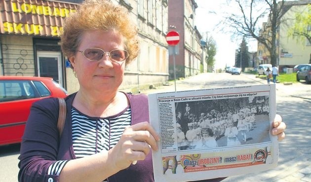 Bożena Omańska na ulicy Harcerskiej 47 lat póżniej. W rękach trzyma egzemplarz naszej gazety ze zdjęciem, na którym wśród innych dzieci rozpoznała samą siebie.