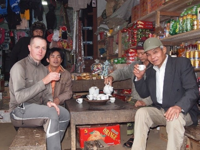 Przemysław Biernat popija zieloną herbatę z Wietnamczykami. Jak wielokrotnie wspomina, często tak kończy się krótkie zatrzymanie przy jakimś domu. Wietnamczycy są bardzo gościnni.