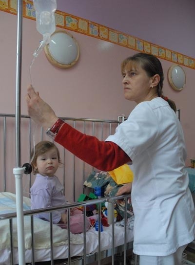 Niespełna półtoraroczna Marika Zdon łatwiej znosi zabiegi wśród kolorowych ścian (na zdjęciu z pielęgniarką pediatrii Renatą Jaworską)