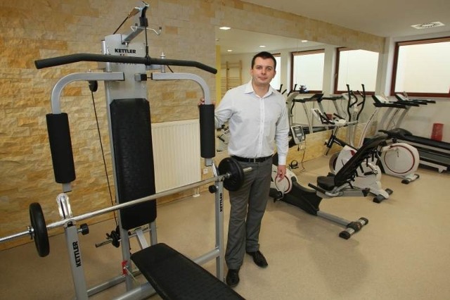 Tomasz Łabędzki, dyrektor hotelu prezentuje salę siłowni z profesjonalnymi urządzeniami do ćwiczeń.
