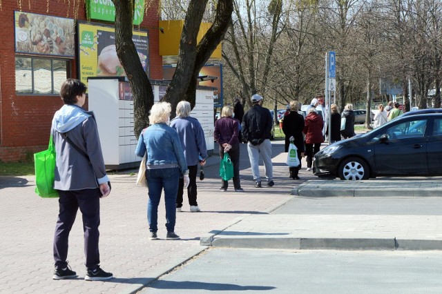 Przedświąteczne kolejki w czasach epidemii koronawirusa. Klienci stoją w odstępach dwumetrowych, a w środku sklepu może przebywać określona ilość kupujących.