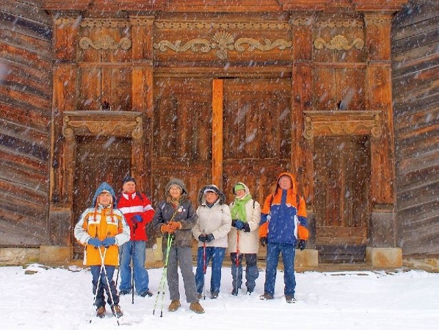 Uczestnicy wyprawy przed zabytkową, drewnianą dzwonnicą kościoła w Krynkach.