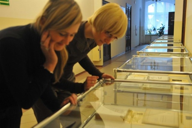 Katarzyna Michalkiewicz i Natalia Hamrol z zainteresowaniem przyglądają się zgromadzonym "pod szybą&#8221; autografom znanych postaci 