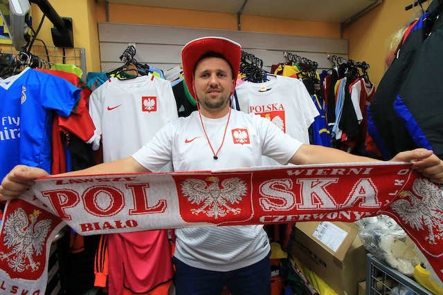 Właściciel salonu piłkarskiego Marcin Wróbel prezentuje gadżety, które najchętniej kupują kibice przed takimi wydarzeniami jak Euro 2016