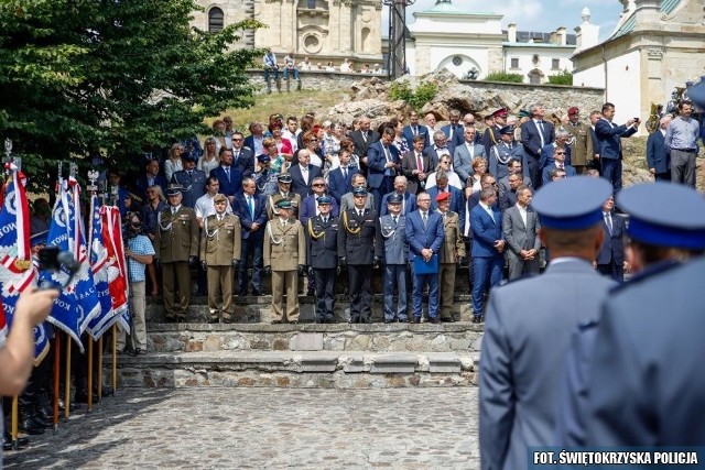 Na terenie klasztoru ojców oblatów na Świętym Krzyżu zorganizowane zostało w piątek wojewódzkie Święta Policji. Tegoroczne obchody przypadają w setną rocznicę powołania Policji Państwowej. Zobacz więcej na kolejnych slajdach. W czasie uroczystości wyróżniono funkcjonariuszy medalami za długoletnią służbę. Otrzymało je 17 stróżów prawa. 19 kolejnych mundurowych uhonorowano odznakami Zasłużony Policjant. Jest w tym gronie zastępca komendanta wojewódzkiego policji w Kielcach podinspektor Andrzej Patrzałek. 18 policjantów otrzymało również akty mianowania na wyższy stopień policyjny.Z okazji Święta Policji świętokrzyscy stróże prawa zapraszają mieszkańców regionu na festyn, który odbędzie się w niedzielę, 21 lipca, na placu Artystów w Kielcach.Od godziny 12 każdy będzie mógł przyjrzeć się pracy świętokrzyskich policjantów. Będzie można odkryć tajniki pracy funkcjonariuszy ruchu drogowego, prewencji, laboratorium kryminalistycznego i wielu innych wydziałów. Każdy z odwiedzających będzie mógł porozmawiać z policjantami i obejrzeć sprzęt, jakim się posługują. Przygotowano wiele atrakcji.– Już w niedzielę na kieleckim placu Artystów wszyscy możecie spotkać się z policjantami garnizonu świętokrzyskiego. To idealna okazja, by zaakcentować setną rocznicę powołania policji – mówi Kamil Tokarski, rzecznik prasowy świętokrzyskiej policji. – Na niedzielnym festynie każdy będzie mógł porozmawiać z funkcjonariuszem wybranego pionu. Odkryć tajemnice naszej służby, sprzęt, który wykorzystujemy w codziennej służbie, pokazy taktyki i techniki interwencji, tresura psów i wiele innych. Świetna zabawa dla całych rodzin.Dorośli będą mogli na przykład podziwiać wystawę policyjnych samochodów i motocykli oraz przetestować alko-gogle. Na młodszych czeka wiele konkursów z nagrodami, zabawa z policyjną maskotką Koziołkiem. Na stoisku laboratorium kryminalistycznego chętni będą mogli zobaczyć, na czym polega pobieranie odcisków linii papilarnych na pamiątkowych kartach daktyloskopijnych. Będą pokazy tresury psów i cała masa wystaw – od tej związanej z okrągłą rocznicą powstania policji, po prace młodzieży i dzieci oraz wystaw.ZOBACZ TAKŻE: Flesz – FOMO, groźne uzależnienie PolakówŹródło: vivi24