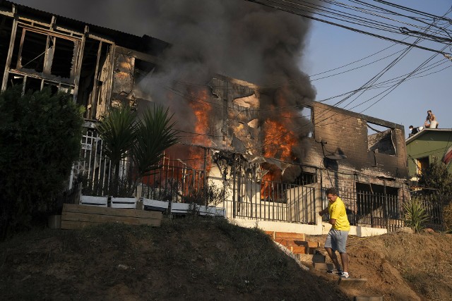 Mieszkańcy próbują opanować pożar w domu w El Olivar, dzielnicy Vina del Mar dotkniętej gwałtownym pożarem