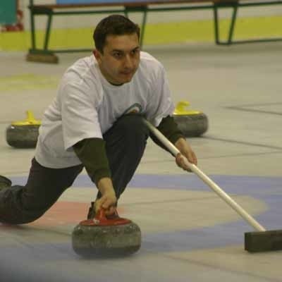 Arkadiusz Stępniak przygotowuje się do kolejnego ślizgu podczas mistrzostw Polski w curlingu